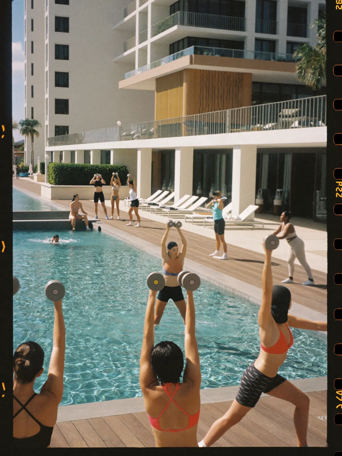 A strength class with dumbbells on an elegant hotel pool deck in the morning