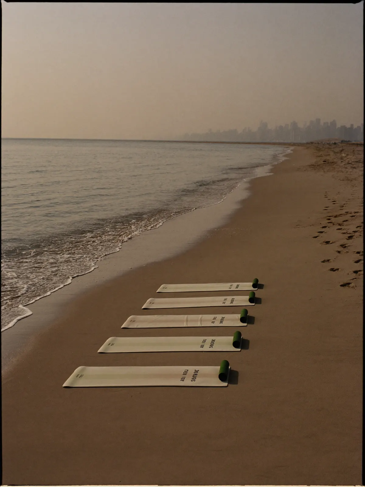 Exercise mats laid out on an empty beach at golden hour