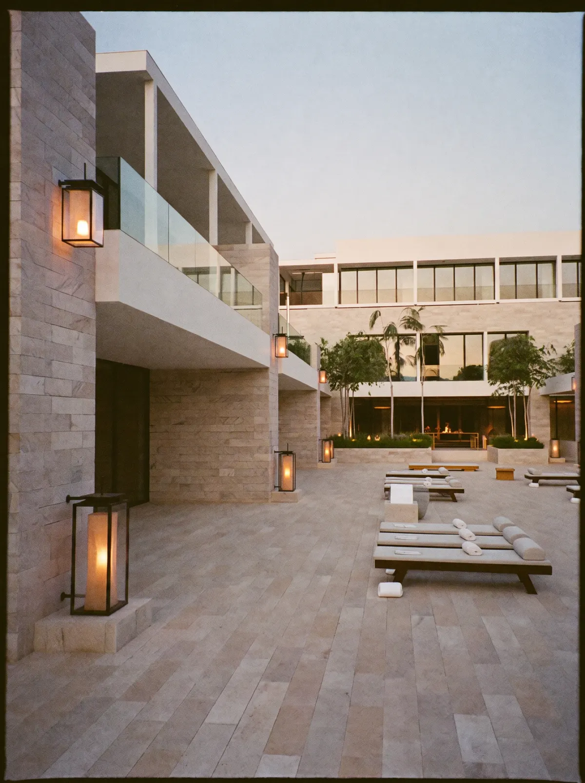 An elegant modern hotel courtyard terrace in warm evening light